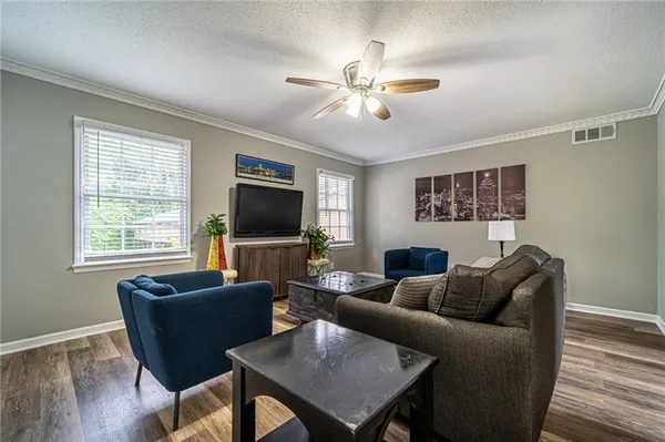 a living room with furniture a flat screen tv and a window