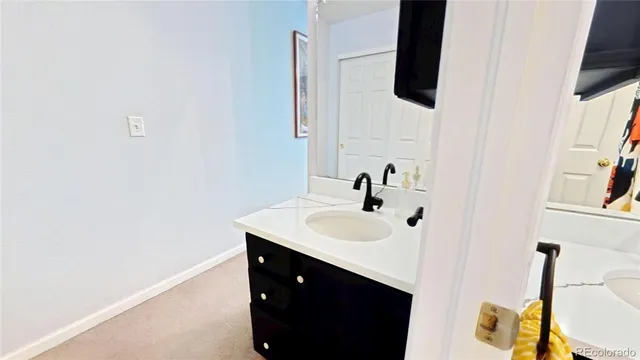 a bathroom with a sink and mirror with bathtub