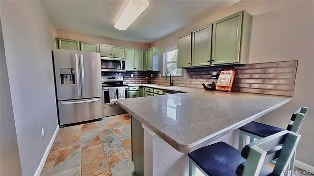 a kitchen with stainless steel appliances granite countertop a sink refrigerator and microwave