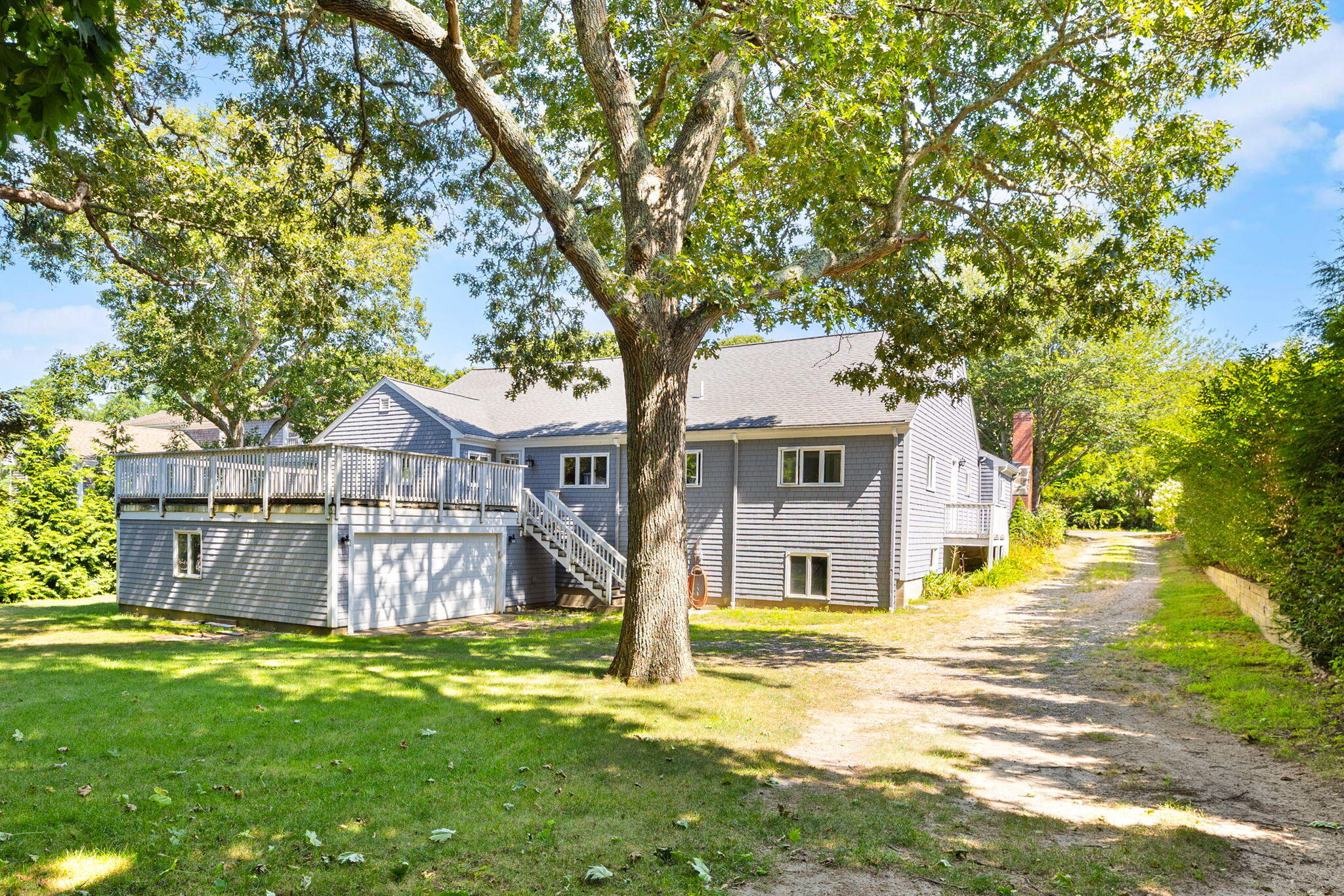 89 Swift Avenue Osterville, MA 02655 - Photo 10 of 57 a front view of a house with a big yard and large tree