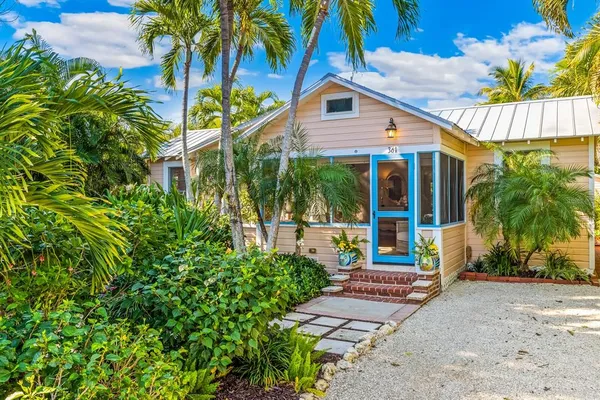 front view of a house with a yard and potted plants