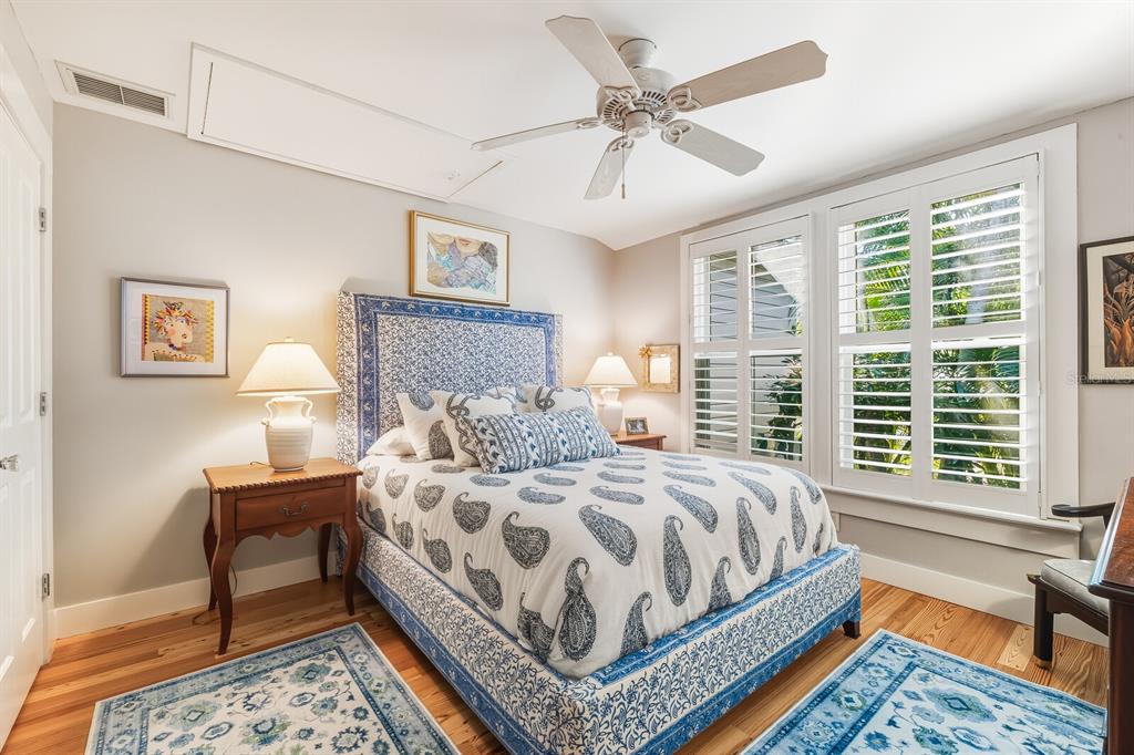 361 Tarpon Avenue Boca Grande, FL 33921 - Photo 16 of 25 a bedroom with a bed a couch and a dresser with wooden floor