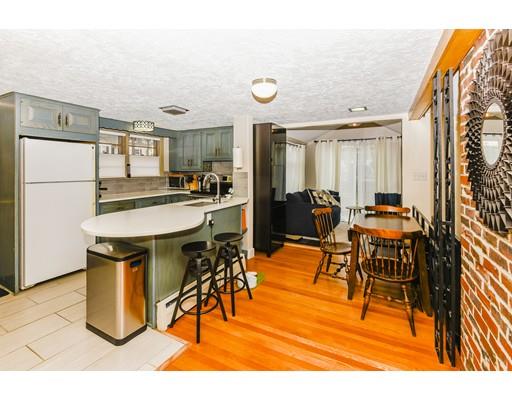360 Sprague Street Dedham, MA 02026 - Photo 5 of 19 a kitchen with stainless steel appliances kitchen island granite countertop dining table chairs and a refrigerator