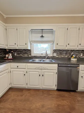 a kitchen with granite countertop white cabinets and white appliances