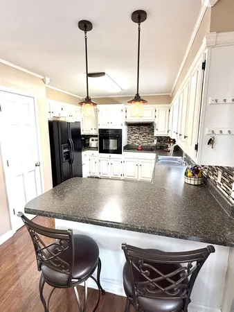 a kitchen with a dining table chairs and large windows