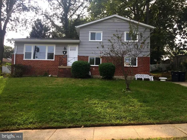 a front view of a house with a garden and yard