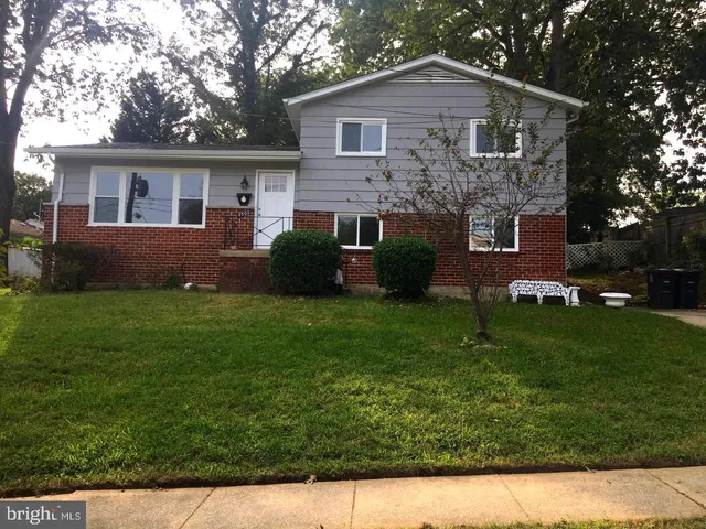 a front view of a house with a garden and yard
