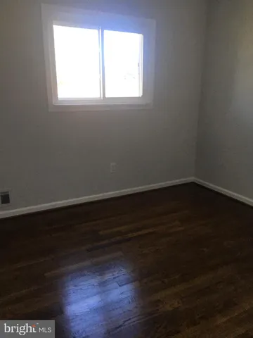a view of a small space with wooden floor and a window