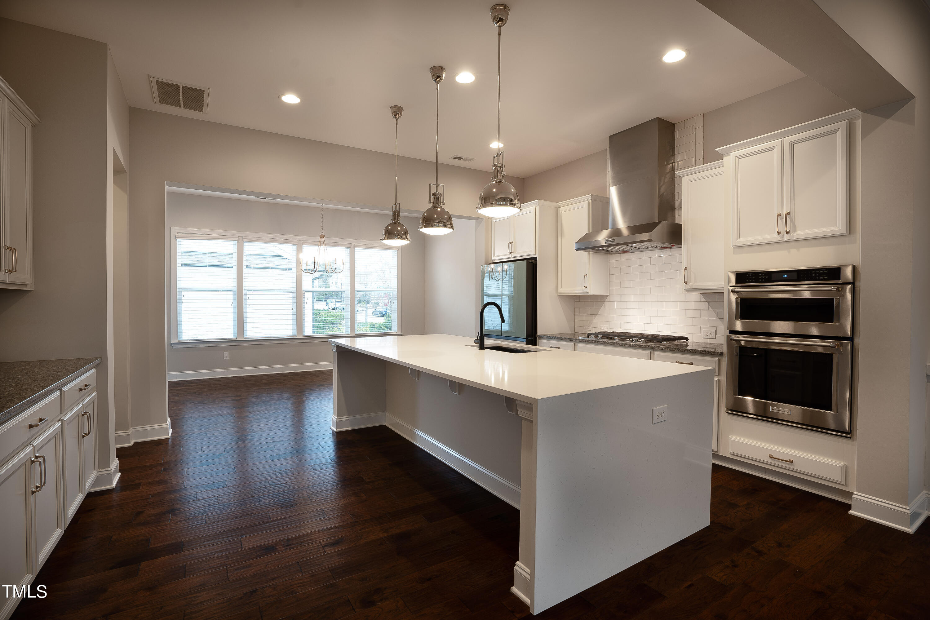 665 Old Dairy Drive Wake Forest, NC 27587 - Photo 6 of 30 a kitchen with stainless steel appliances kitchen island granite countertop a stove and a wooden floors