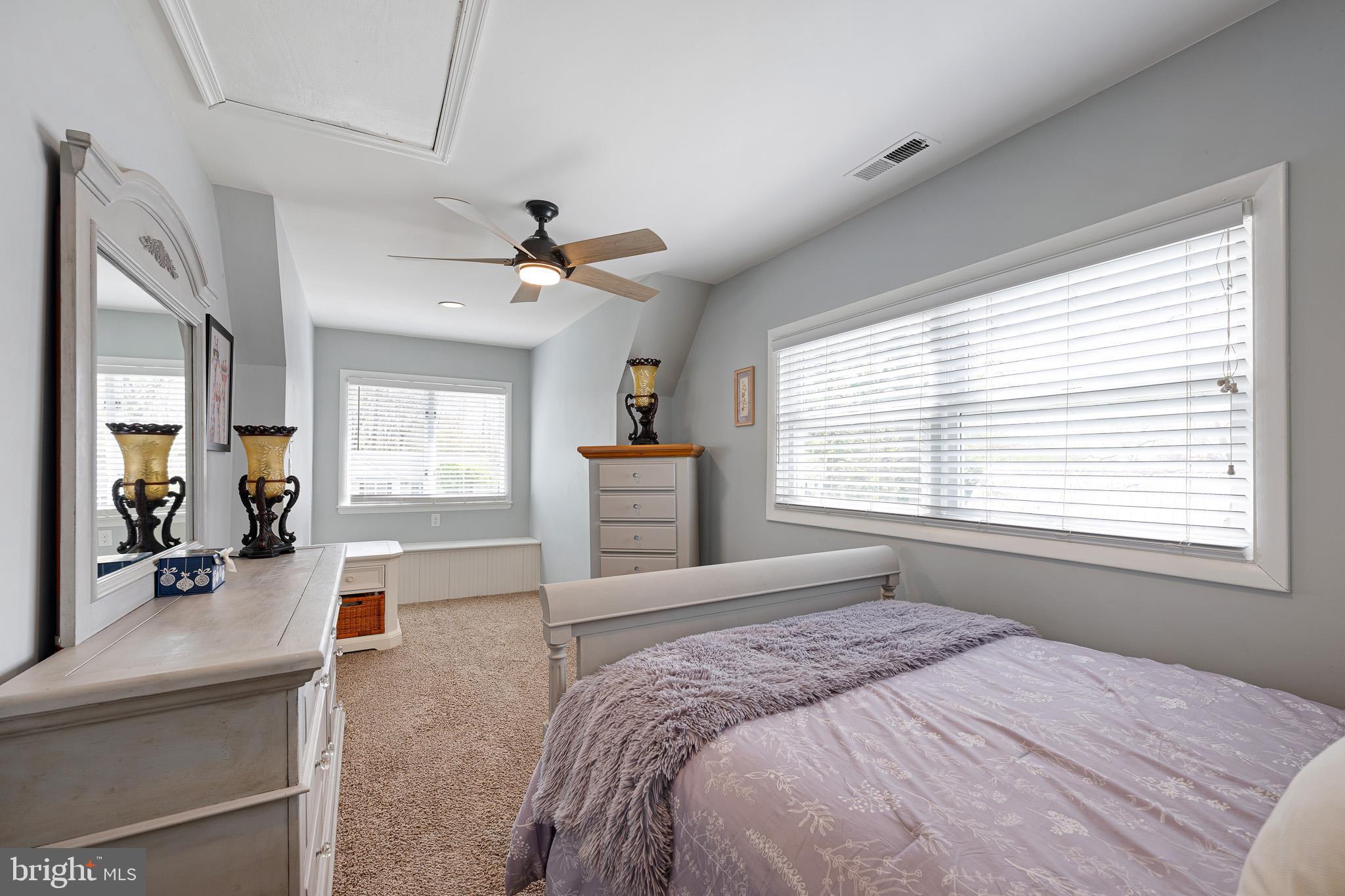 31186 Dogwood Acres Road Dagsboro, DE 19939 - Photo 27 of 43 a bedroom with a large bed a chandelier and windows