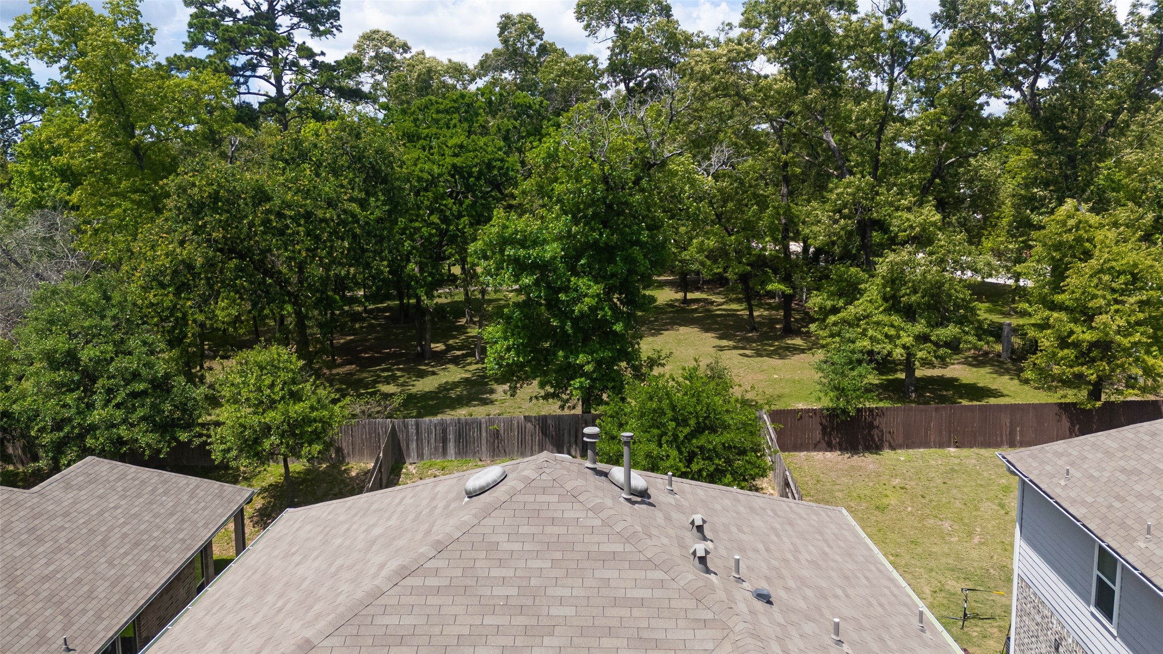 2107 Parnevik Place Conroe, TX 77304 - Photo 39 of 44 Charming two-story home nestled on a quiet street, offering rare privacy with no rear neighbors and a lush, wooded backdrop that creates a peaceful, park-like setting.