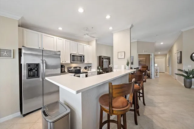a kitchen with stainless steel appliances a table chairs refrigerator and microwave