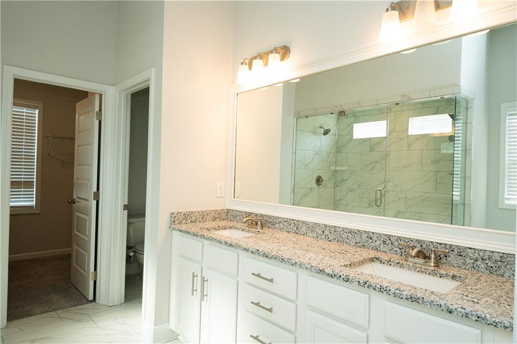 536 Sageton Court Grayson, GA 30017 - Photo 24 of 37 a bathroom with a granite countertop sink and a mirror