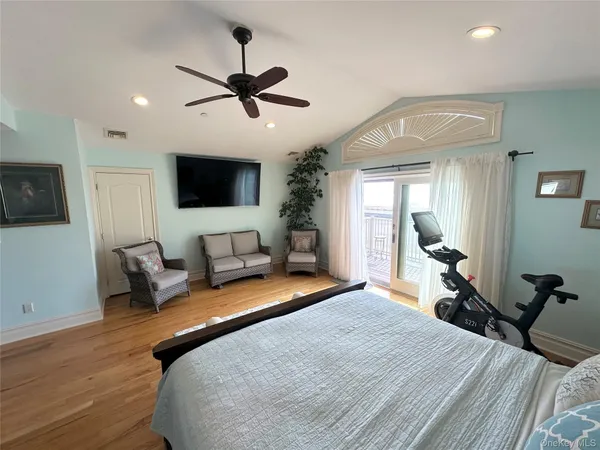 a spacious bedroom with a bed a couch and a flat screen tv