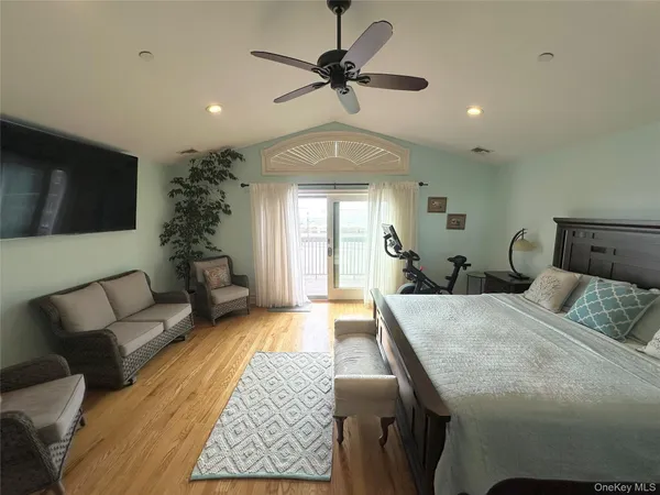 a bedroom with a bed a couch and a flat screen tv