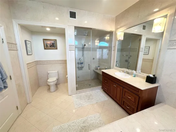 a bathroom with a double vanity sink toilet and shower