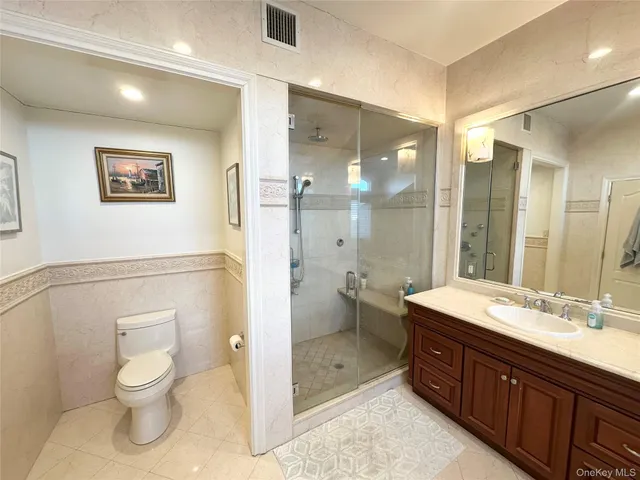 a spacious bathroom with a double vanity sink toilet and shower