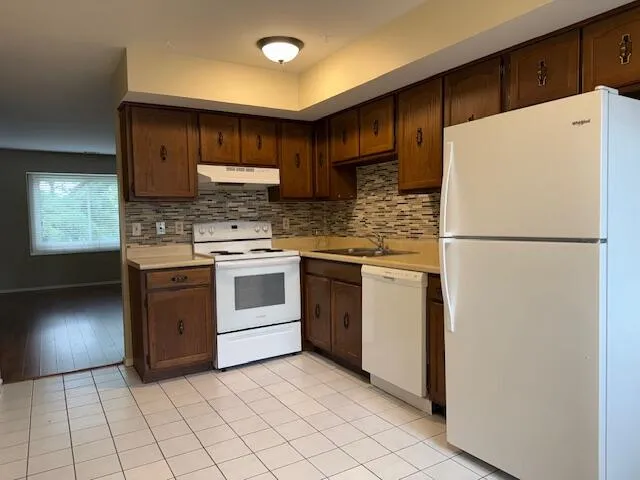 a kitchen with a stove a refrigerator and a stove top oven
