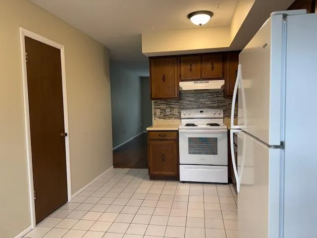 a kitchen with a stove top oven and cabinets