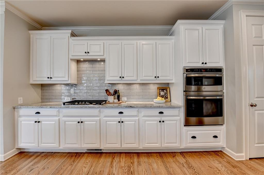 7051 Dove Point Lane Hoschton, GA 30548 - Photo 15 of 74 a kitchen with stainless steel appliances white cabinets and a stove top oven