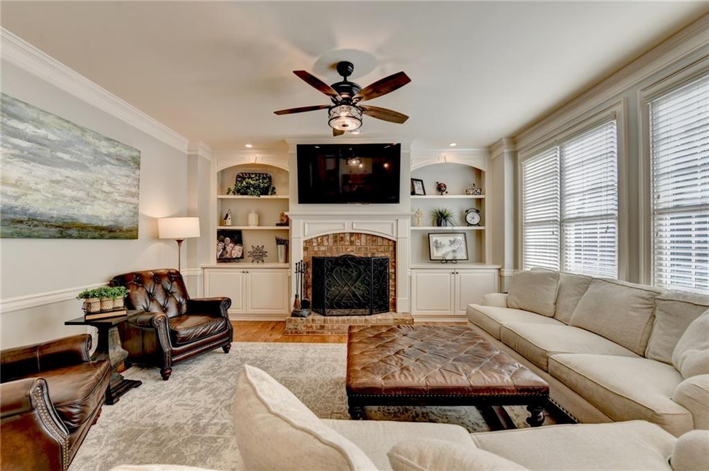 7051 Dove Point Lane Hoschton, GA 30548 - Photo 22 of 74 a living room with furniture a flat screen tv and a fireplace