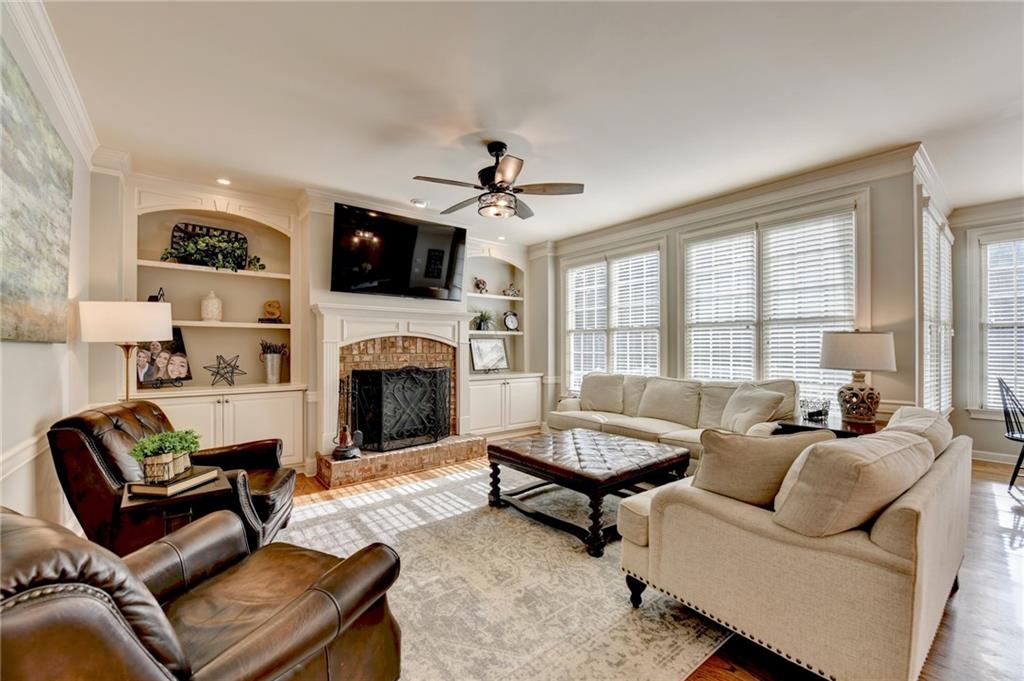 7051 Dove Point Lane Hoschton, GA 30548 - Photo 23 of 74 a living room with furniture a flat screen tv and a fireplace