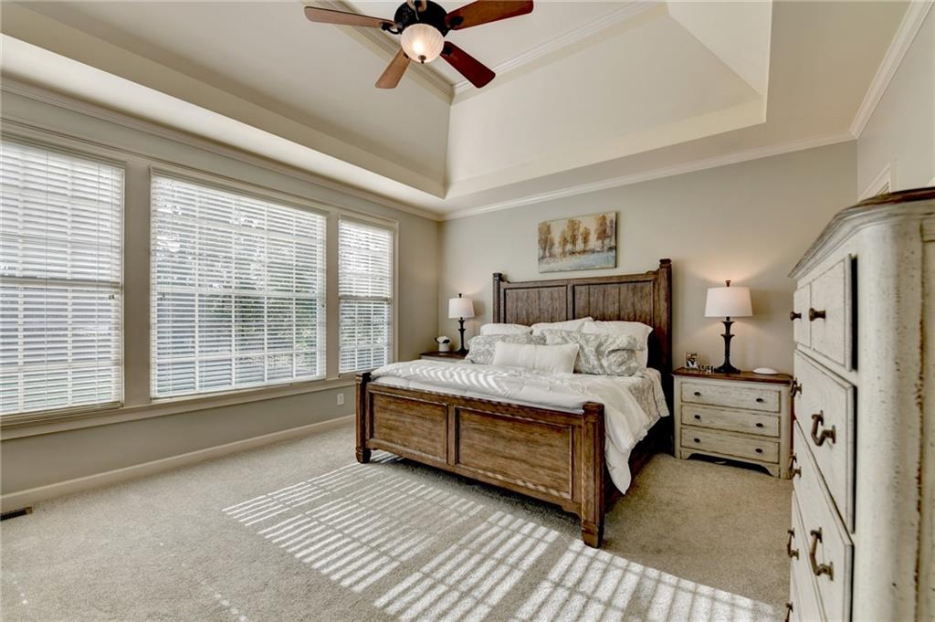 7051 Dove Point Lane Hoschton, GA 30548 - Photo 26 of 74 a spacious bedroom with a bed and a large window