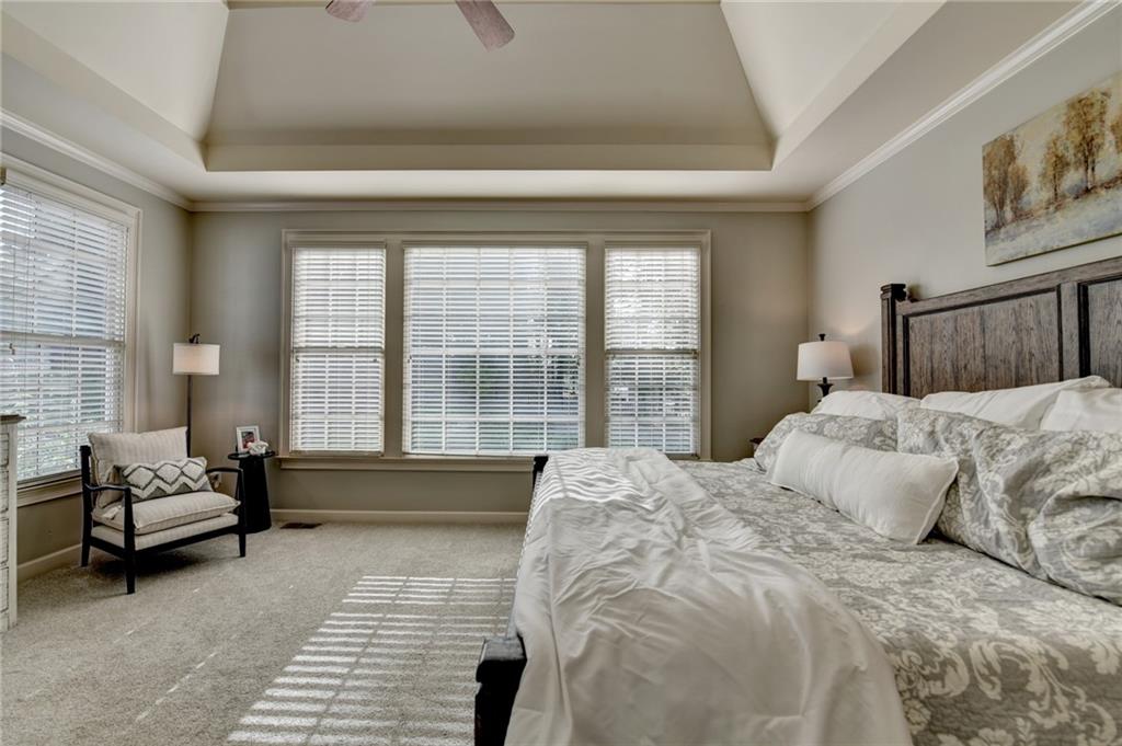 7051 Dove Point Lane Hoschton, GA 30548 - Photo 30 of 74 a spacious bedroom with a bed and a couch