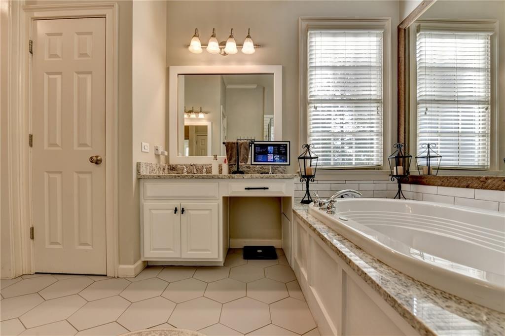7051 Dove Point Lane Hoschton, GA 30548 - Photo 31 of 74 a bathroom with a granite countertop sink and a bathtub