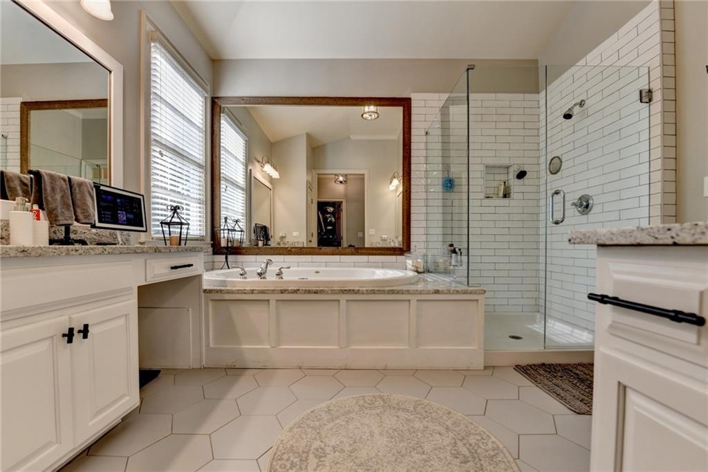 7051 Dove Point Lane Hoschton, GA 30548 - Photo 33 of 74 a bathroom with a granite countertop sink mirror and bathtub