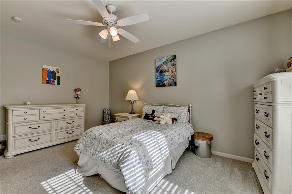 7051 Dove Point Lane Hoschton, GA 30548 - Photo 36 of 74 a bedroom with a bed and a chandelier