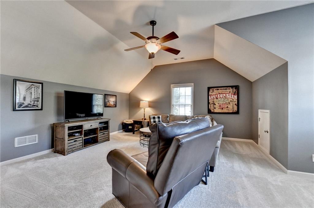 7051 Dove Point Lane Hoschton, GA 30548 - Photo 41 of 74 a living room with furniture and a flat screen tv