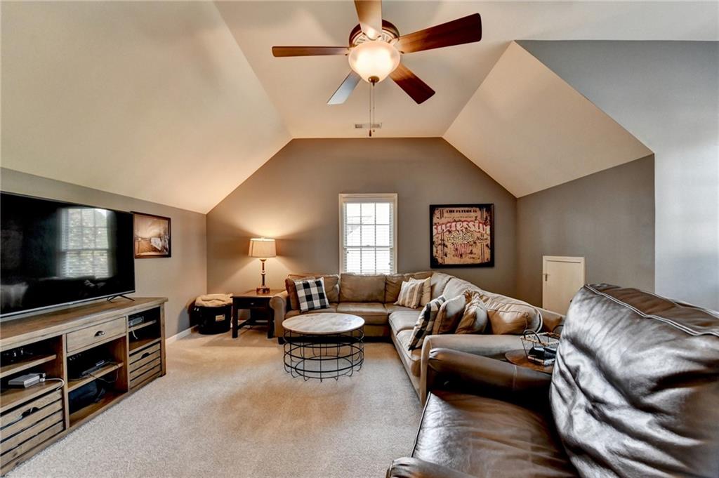 7051 Dove Point Lane Hoschton, GA 30548 - Photo 42 of 74 a living room with furniture and a flat screen tv