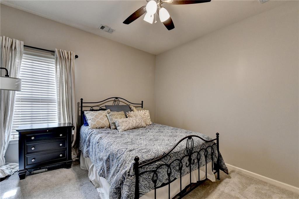7051 Dove Point Lane Hoschton, GA 30548 - Photo 44 of 74 a bedroom with a bed and a ceiling fan