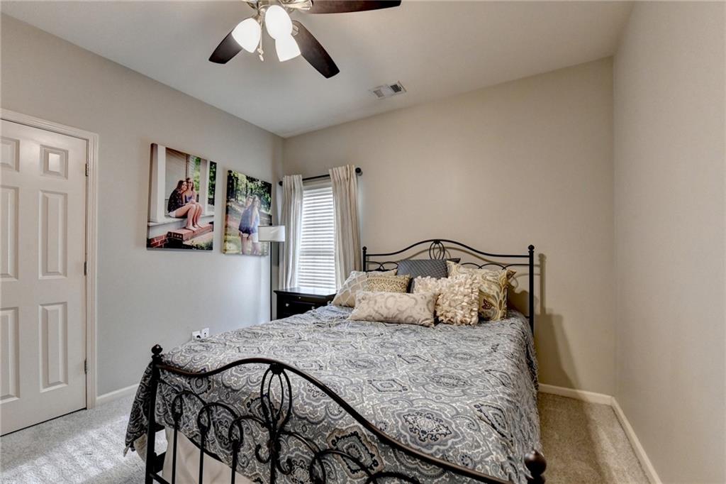 7051 Dove Point Lane Hoschton, GA 30548 - Photo 45 of 74 a bedroom with a large bed and a chandelier
