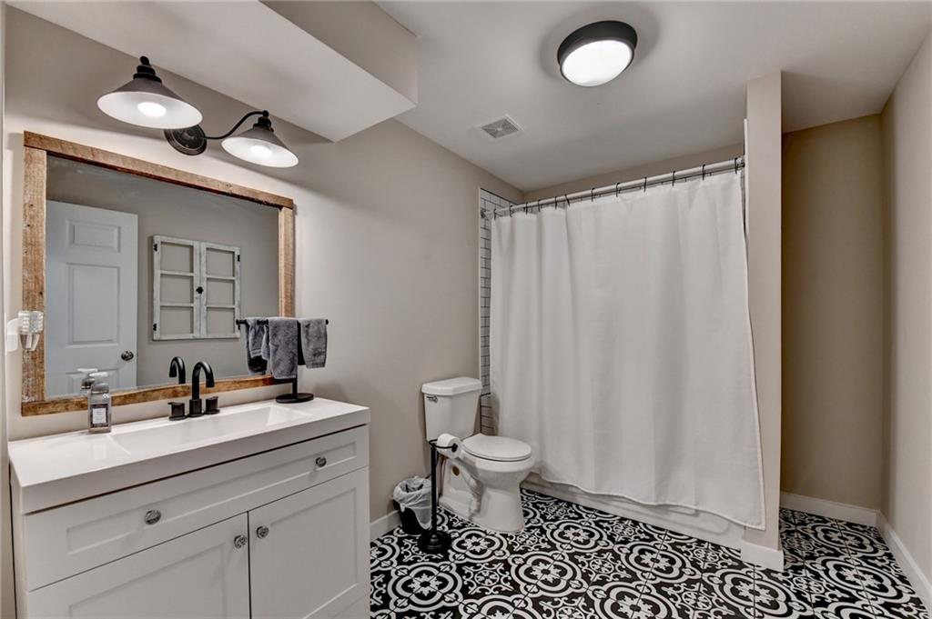 7051 Dove Point Lane Hoschton, GA 30548 - Photo 59 of 74 a bathroom with a double vanity sink toilet and a mirror