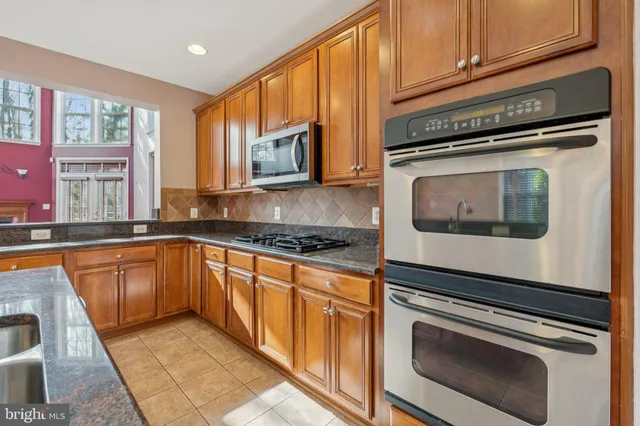 a kitchen with granite countertop cabinets stainless steel appliances and a window