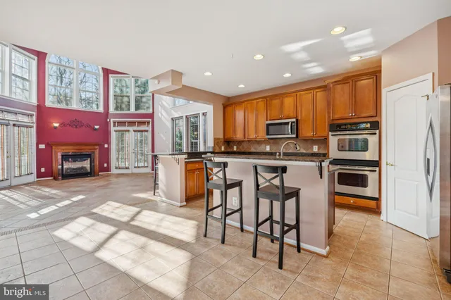 a kitchen with stainless steel appliances granite countertop a refrigerator and a stove top oven