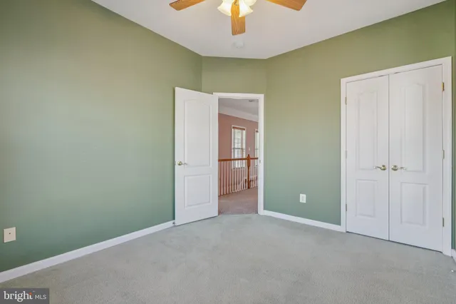 a view of an empty room with a chandelier fan
