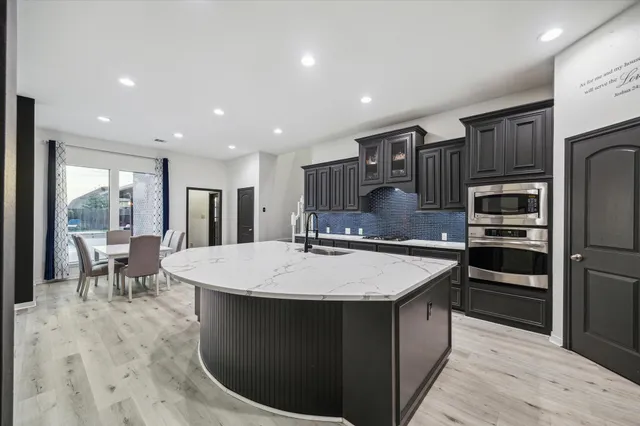 a large kitchen with kitchen island a sink table and chairs