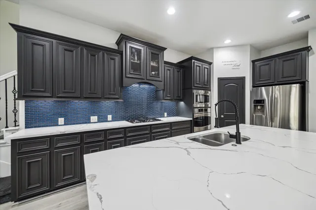 a kitchen with stainless steel appliances granite countertop a sink stove and refrigerator