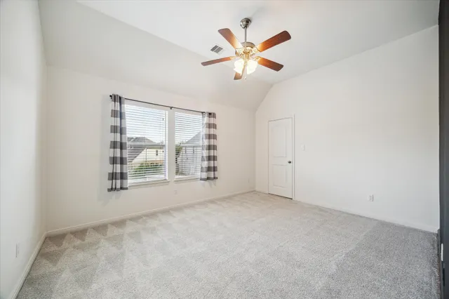 an empty room with windows and fan