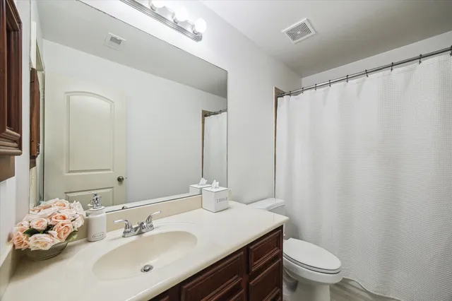 a bathroom with a sink vanity mirror and toilet