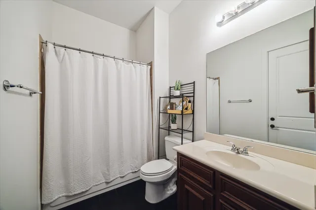 a bathroom with a sink a toilet and shower curtain