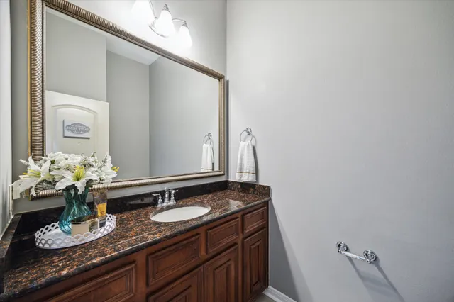 a bathroom with a granite countertop sink and a mirror