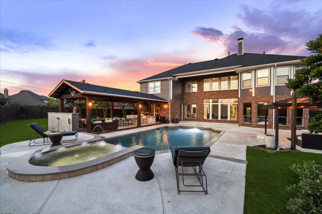 a front view of a house with swimming pool having outdoor seating