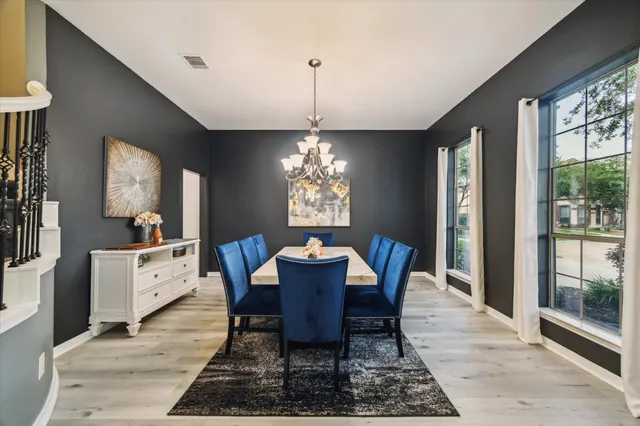 a dining room with furniture a chandelier and window