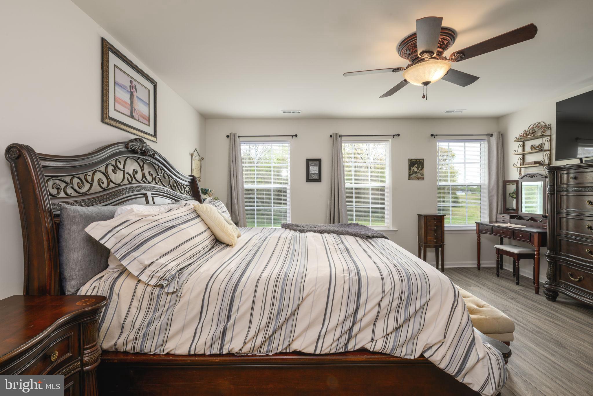 28008 King Farms Road Laurel, DE 19956 - Photo 19 of 44 a bedroom with a large bed and a chandelier