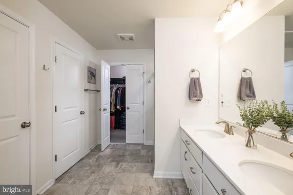 a en suite bathroom with a shower sink and mirror