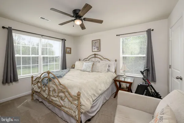a bedroom with a bed and a flat tv screen on dresser